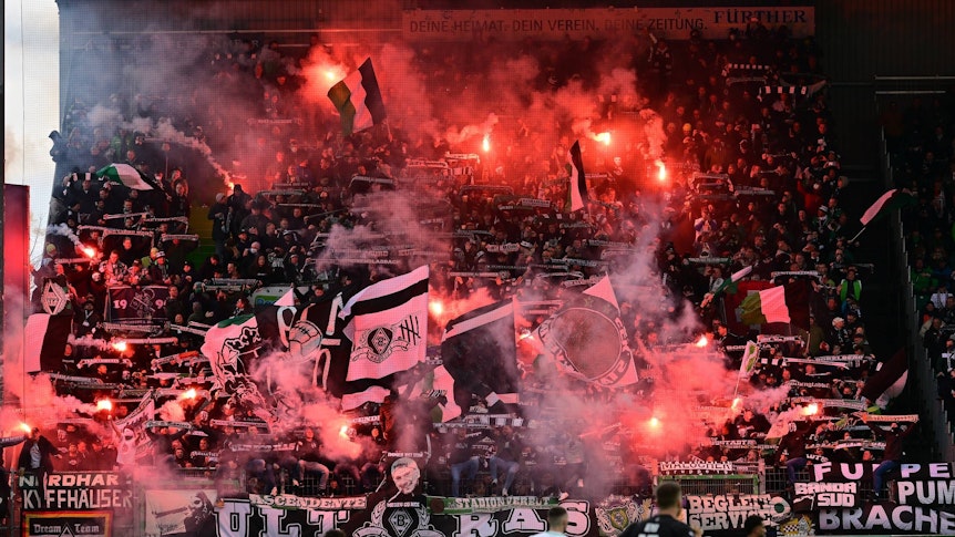 Fohlen-Fans im Gäste-Block während der Bundesliga-Partie zwischen Greuther und Borussia Mönchengladbach am 9. April 2022. Es sind Bengalos zu sehen.
