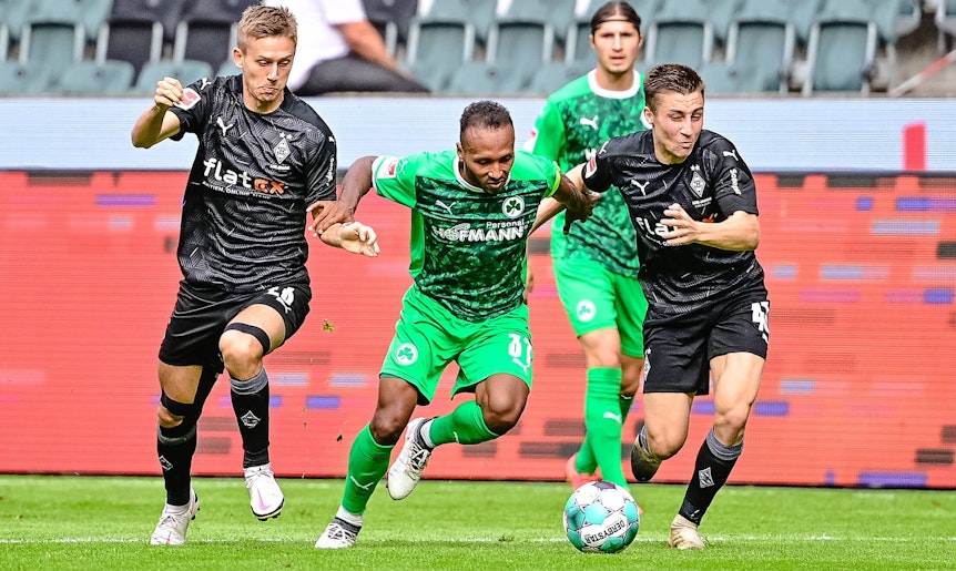 Torben Müsel (l.) und Rocco Reitz (r.) im Trikot von Fußball-Bundesligist Borussia Mönchen im Duell mit Julian Green (M.) von Greuther Fürth. Diese Aufnahme ist während eines Testspiels am 27. August 2020 im Borussia-Park entstanden. Alle drei Spieler kämpfen um den Ball.