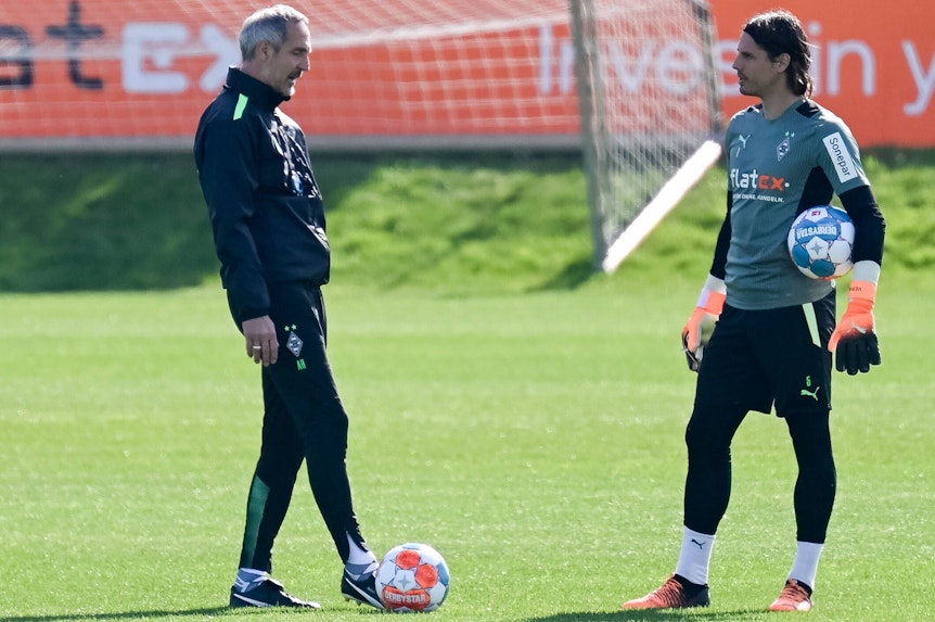 Gladbach-Cheftrainer Adi Hütter (l.) im Gespräch mit Torhüter Yann Sommer (r.) während einer Trainingseinheit am 19. April 2022 im Borussia-Park. Sommer hält einen Ball im Arm.