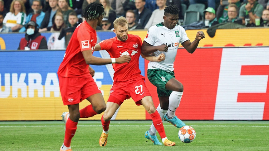 Gladbach-Stürmer Breel Embolo (r.) im Duell mit Konrad Laimer (M.) von RB Leipzig während des Bundesliga-Duells am Montag (2. Mai 2022) im Borussia-Park. Beide Spieler haben den Ball im Blick.