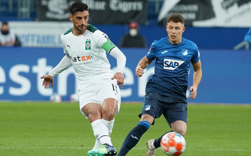 Ein durchaus umkämpftes Hinspiel: Hier zu sehen Lars Stindl (l.) und Dennis Geiger (r.) während der Partie zwischen der TSG Hoffenheim und Borussia Mönchengladbach am 18. Dezember 2021.