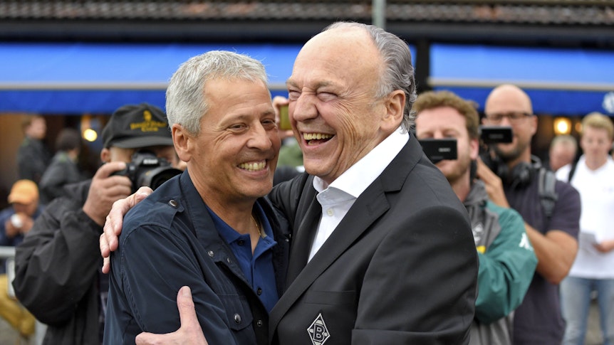 Lucien Favre zusammen mit Präsident Rolf Königs am 20. Juli 2017 bei einem Testspiel von Borussia Mönchengladbach gegen OGC Nizza. Beide umarmen sich und lachen gemeinsam.