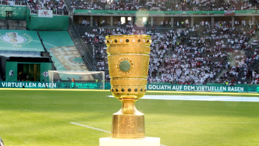 Der DFB-Pokal im Berliner Olympiastadion. Auf diesem Foto ist die Trophäe am 21. Mai 2022 zu sehen. Die Sonne scheint den goldenen Pokal an.
