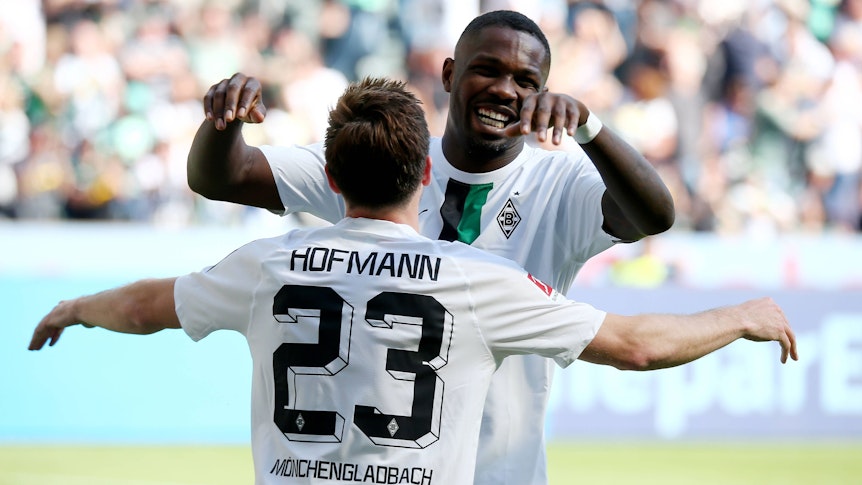 Gladbach-Stürmer Marcus Thuram jubelt mit Team-Kollege Jonas Hofmann über einen Treffer im Bundesliga-Duell gegen die TSG Hoffenheim am 14. Mai 2022 im Borussia-Park. Die beiden Borussen umarmen sich.