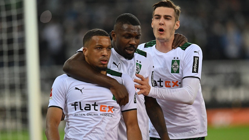 Die Gladbach-Profis Alassane Plea, Marcus Thuram und Florian Neuhaus (v.l.n.r.) am 12. März 2022 im Bundesliga-Duell gegen Hertha BSC im Borussia-Park. Sie bejubeln ein Tor für Gladbach.