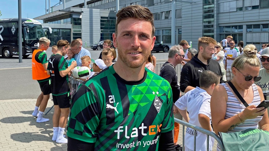 Tobias Sippel, Torhüter von Fußball-Bundesligist Borussia Mönchengladbach, gibt am Donnerstag (30. Juni 2022) Autogramme im Borussia-Park. Sippel blickt in die Kamera des Fotografen und lächelt.