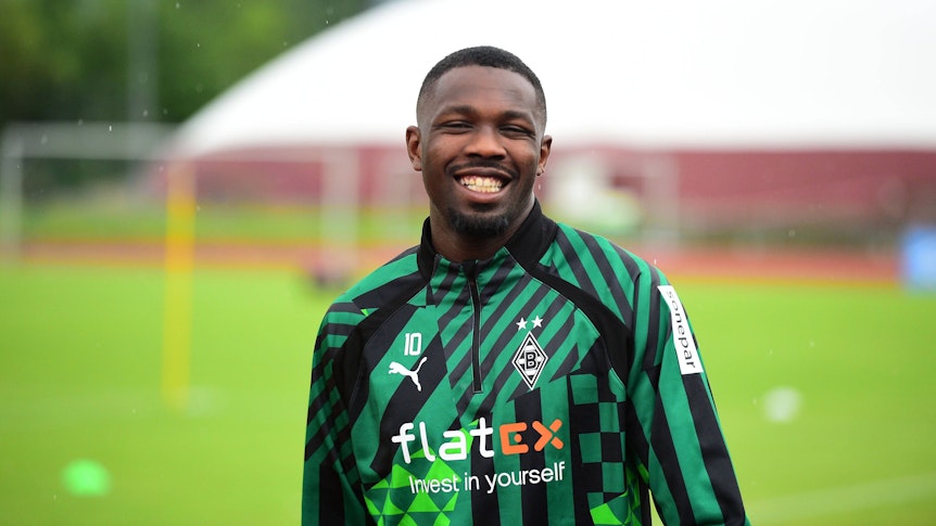 Borussia-Mönchengladbach-Star Marcus Thuram, hier am 4. Juli 2022 im Trainingslager der Borussia, könnte Gladbach wohl erhalten bleiben. Thuram lächelt in die Kamera.