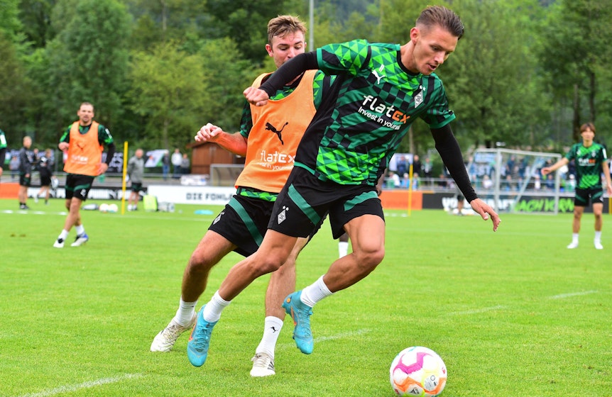Hannes Wolf (r.) im Duell mit Christoph Kramer (l.) während des Trainingslagers von Fußball-Bundesligist Borussia Mönchengladbach am bayrischen Tegernsee. Dieses Foto stammt von 8, Juli 2022. Wolf und Kramer kämpfen um den Ball auf der Sportanlage Birkenmoos.