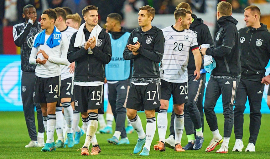 Gladbach-Profi Florian Neuhaus (rechts, im Vordergrund) schreitet gemeinsam mit Julian Weigl (l.) nach dem Länderspiel der DFB-Elf gegen Israel am 26. März 2022 über den Rasen der Arena in Sinsheim. Neuhaus und Weigl klatschen in die Hände.