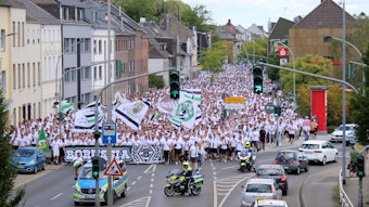 Tausende Menschen haben am Marsch der aktiven Fanszene von Borussia Mönchengladbach vor dem Bundesliga-Heimspiel am 6. August 2022 gegen die TSG Hoffenheim teilgenommen. Die Polizei regelt den Straßenverkehr.
