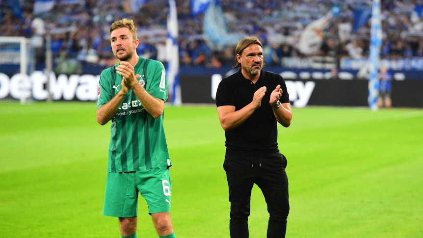 Gladbach-Profi Christoph Kramer (l.) und Trainer Daniel Farke (r.) nach dem Unentschieden von Fußball-Bundesligist Borussia Mönchengladbach beim FC Schalke 04 am 13. August 2022. Die beiden klatschen in die Hände.