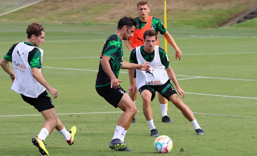Gladbach-Kapitän Lars Stindl (2.v.l.) mischt im Mannschaftstraining wieder voll mit und könnte nach seiner Muskel-Verletzung für das Bundesliga-Duell gegen Hertha BSC (19. August 2022) wieder eine Kader-Option sein. Auf diesem Foto ist Stindl am 16. August zu sehen. Er spielt den Ball.
