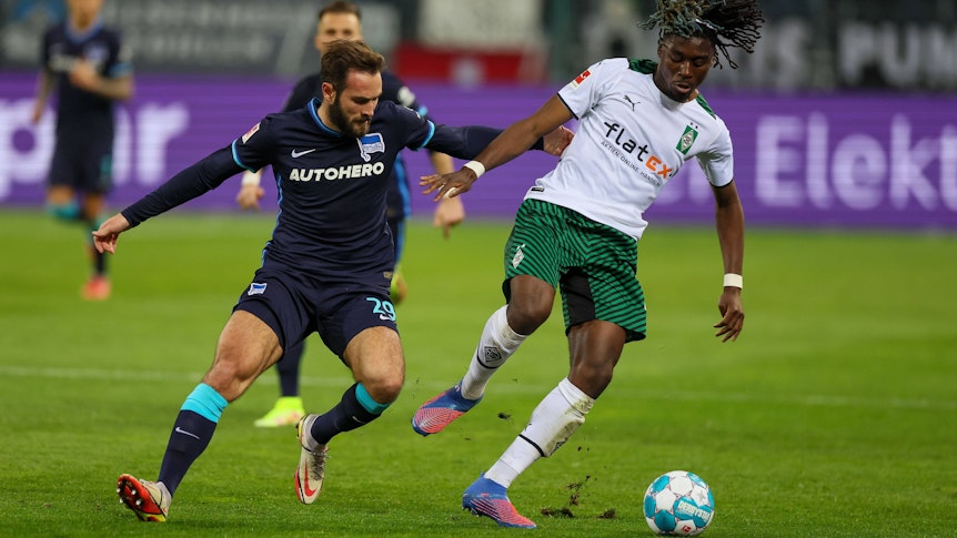 Borussia Mönchengladbach empfängt am Freitag (19. August 2022) Hertha BSC zum Auftakt des 3. Bundesliga-Spieltags. Das Foto zeigt Gladbachs Manu Koné Thuram (re.) im Zweikampf mit Berlins Lucas Tousart (li.) beim vergangenen Duell am 12. März 2022.