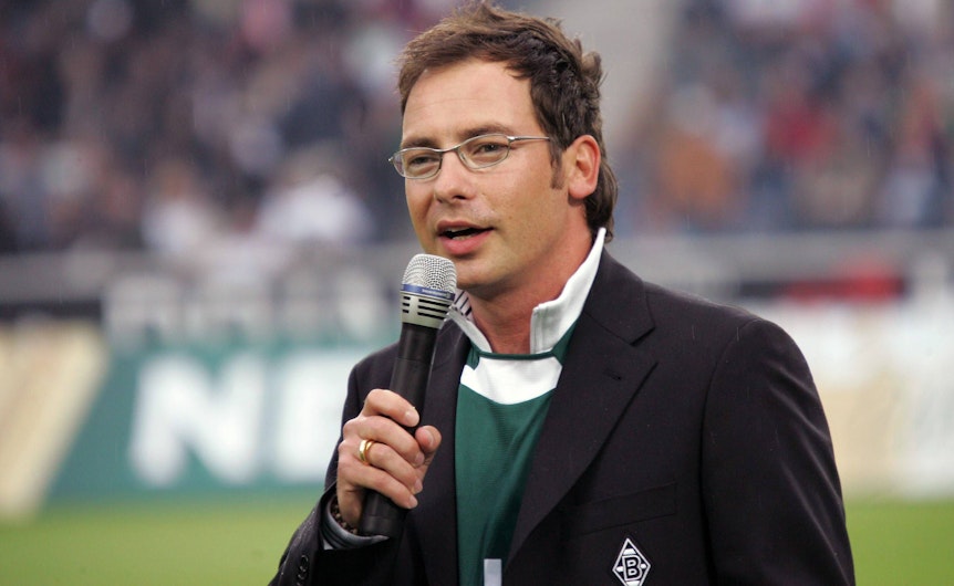 TV-Moderator Matthias Opdenhövel hat als Stadionsprecher für Fußball-Bundesligist Borussia Mönchengladbach gearbeitet. Auf diesem Bild ist der 51-Jährige am 22. Juli 2005 im Gladbacher Stadion zu sehen. Opdenhövel hält ein Mikrofon in der Hand.