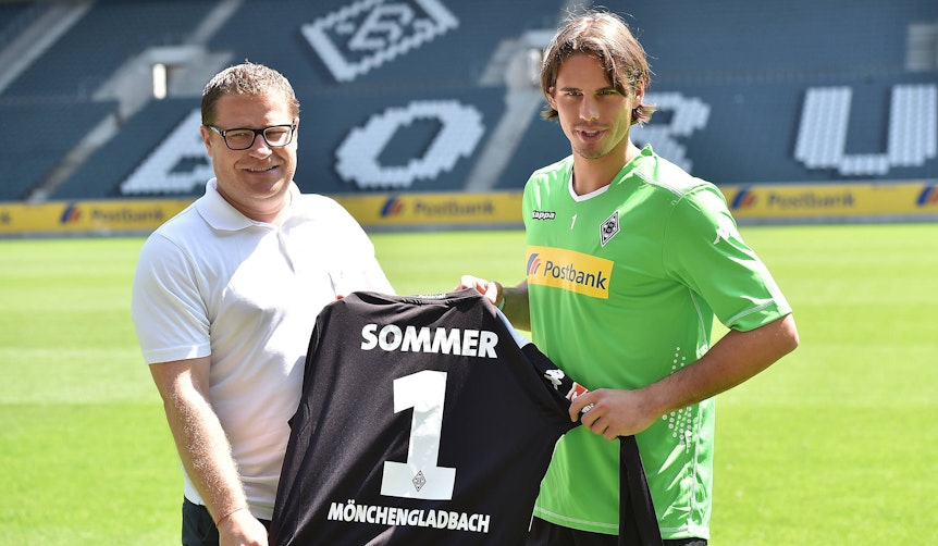 Gladbach-Keeper Yann Sommer (r.) und Ex-Borussia-Manager Max Eberl (l.), hier zu sehen am 23. Juli 2014 im Borussia-Park. Die beiden halten ein Trikot mit der Rückennummer eins in den Händen.