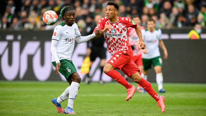Gladbachs Manu Koné (l.) im Zweikampf mit dem Mainzer Karim Onisiwo (r.). Das Foto stammt vom letzten Aufeinandertreffen von Borussia Mönchengladbach und Mainz 05 am 3. April 2022 im Borussia-Park.