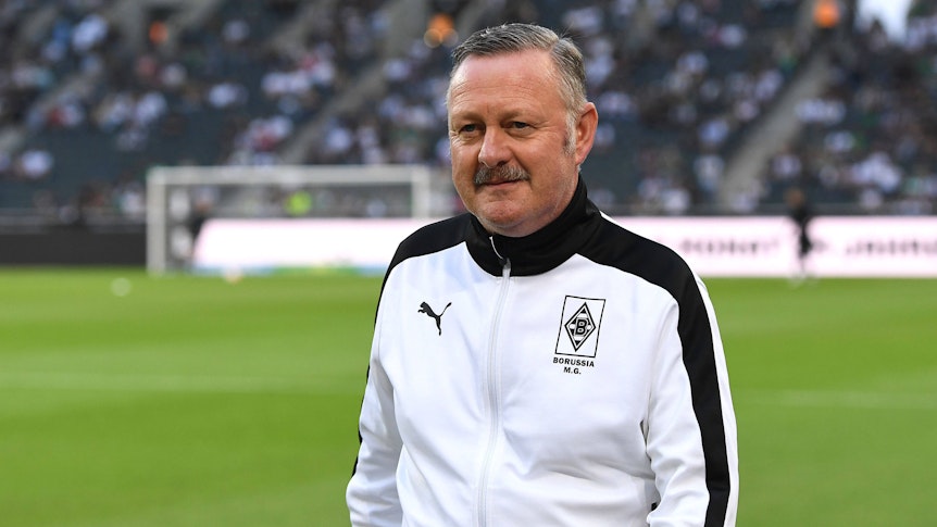 Gladbach-Manager Roland Virkus, hier am 19. August 2022 im Borussia-Park vor der Bundesliga-Partie der Fohlen-Elf gegen Hertha BSC zu sehen. Virkus trägt eine weiß-schwarze Trainingsjacke von Puma mit Borussia-Logo.