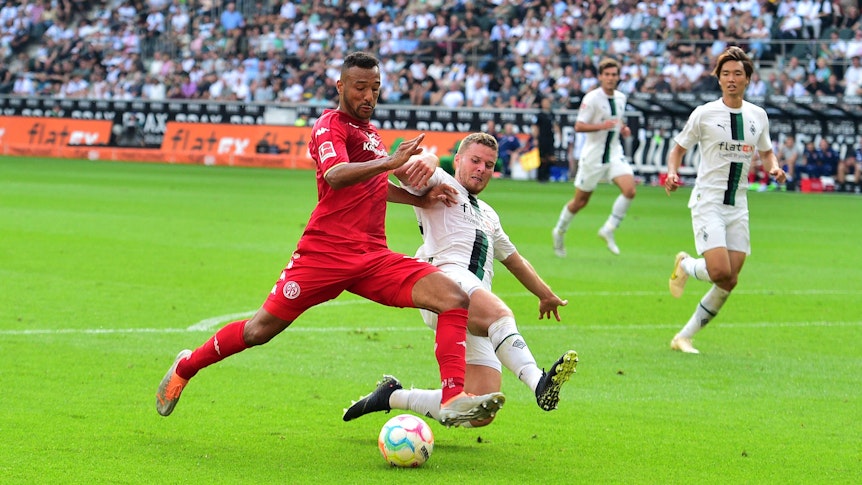 Gladbach-Verteidiger Nico Elvedi (r.) im Zweikampf mit dem Mainzer Karim Onisiwo (l.) im Bundesliga-Duell am 4. September 2022 im Borussia-Park. Elvedi setzt zur Grätsche an.