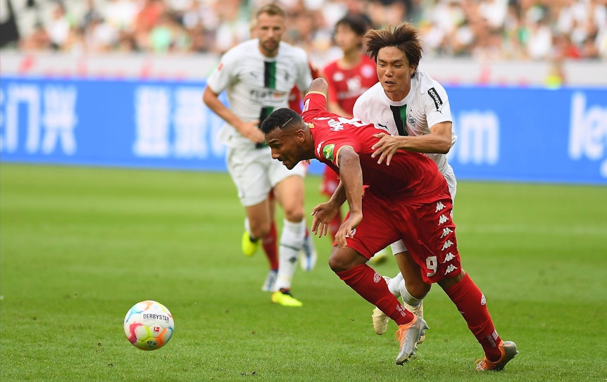 Notbremse! In dieser Szene holt sich Gladbach-Verteidiger Ko Itakura (r.) im Zweikampf mit dem Mainzer Karim Onisiwo die Rote Karte ab während des Bundesliga-Duells am Sonntag (4. September 2022) im Borussia-Park. Itakura hält seinen Gegenspieler fest.