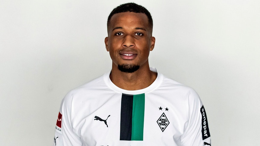 Alassane Plea, Stürmer bei Fußball-Bundesligist Borussia Mönchengladbach in der Saison 2022/2023. Er hat die Arme hinter seinem Rücken verschränkt.