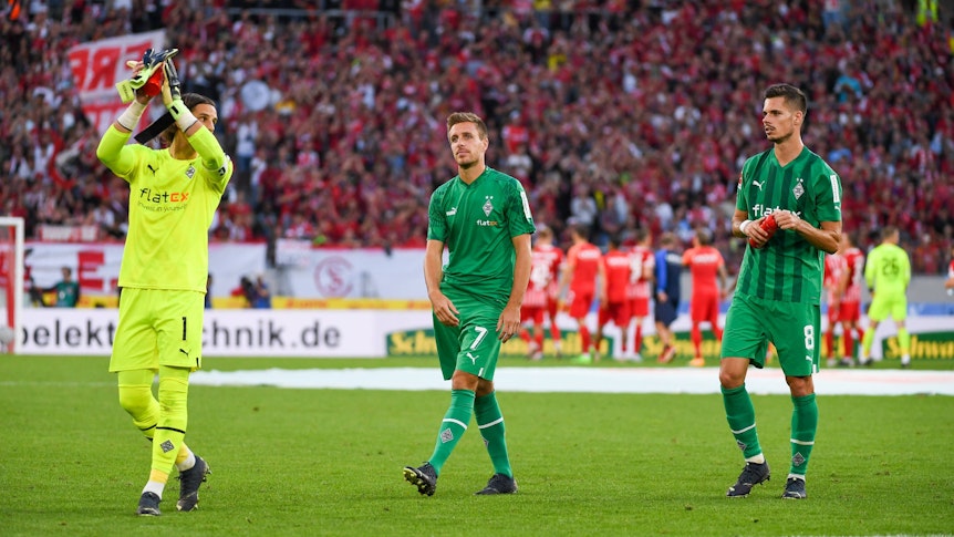 Yann Sommer (l.), Patrick Herrmann (Mitte) und Julian Weigl applaudieren am 11. September 2022 nach dem Match beim SC Freiburg den Fans.