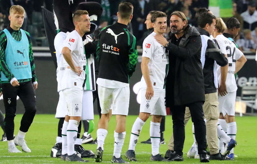 Gladbach-Trainer Daniel Farke mit seinem Matchwinner Jonas Hofmann nach der 3:0-Gala gegen RB Leipzig im Bundesliga-Topspiel am Samstag (17. September 2022) im Borussia-Park. Farke trägt dunkle Kleidung.