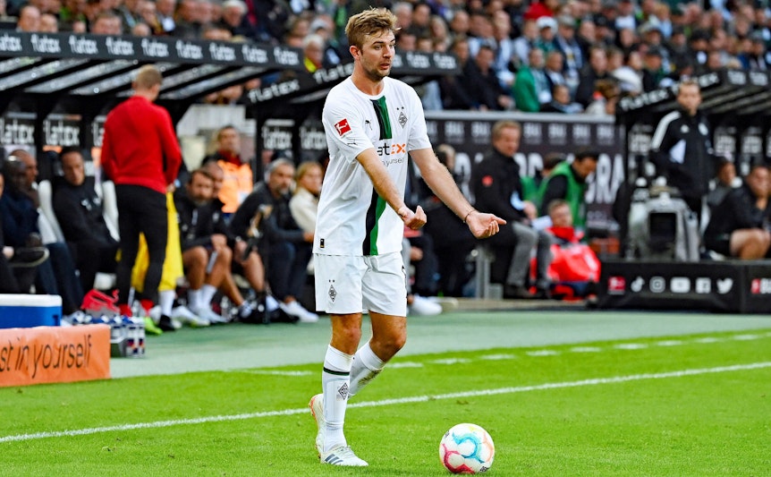 Der Weltmeister von 2014 dirigiert das Spiel von Borussia Mönchengladbach: Mittelfeldakteur Christoph Kramer, hier zu sehen im Bundesliga-Duell mit RB Leipzig (17. September 2022) im Borussia-Park. Kramer hat den Ball vor sich auf dem Rasen liegen und macht mit beiden Händen eine Geste.