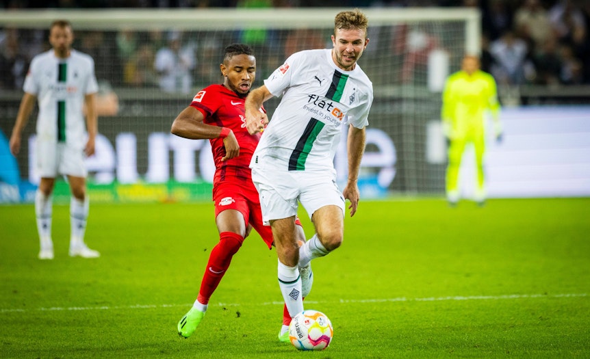 Gladbach-Profi Christoph Kramer (weißes Trikot), auf diesem Bild am 17. September 2022 im Bundesliga-Duell gegen RB Leipzig im Borussia-Park zu sehen. Kramer hat den Ball am Fuß, von hinten bedrängt ihn ein Gegenspieler.