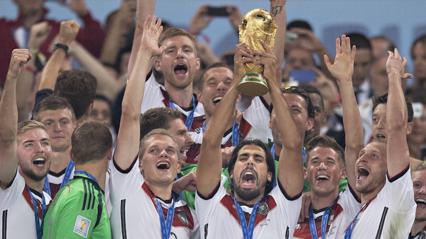Sami Khedira reckt den WM-Pokal gen Nachthimmel von Rio de Janeiro. So geschehen am 13. Juli 2014. Dabei sind auch Matthias Ginter, Manuel Neuer oder Christoph Kramer. Der Weltmeister und ehemalige DFB-Star kommt zum Jugendturnier von Borussia Mönchengladbach in den Borussia-Park.