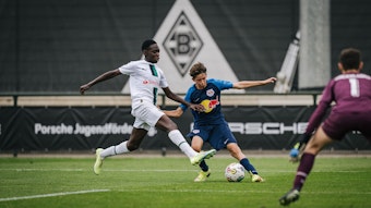 Die U15 von Borussia Mönchengladbach hat den „Porsche Fußball Cup“ 2022 in Mönchengladbach gewonnen. Das Foto stammt vom Vorrundenspiel gegen RB Salzburg am 24. September 2022. Ein Salzburger Angreifer ist im Zweikampf mit einem Gladbacher Verteidiger.
