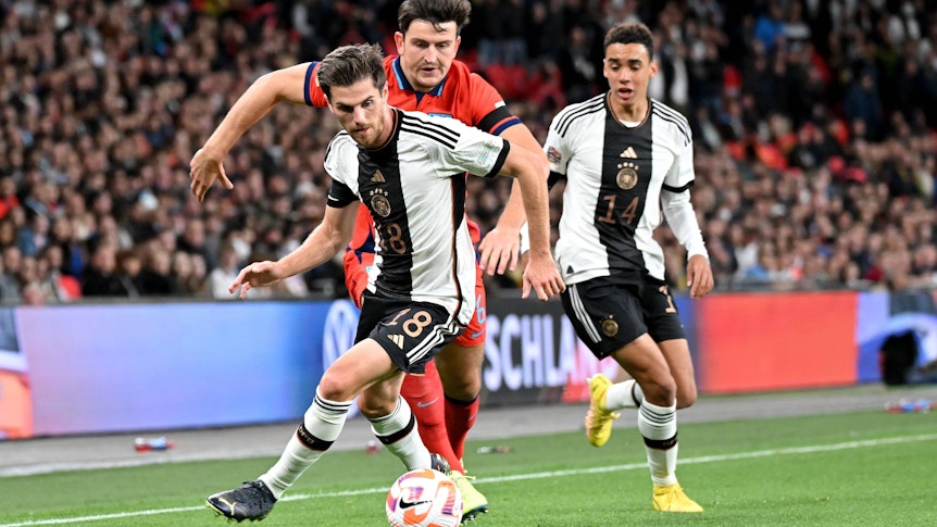 Jonas Hofmann (vorne) von Borussia Mönchengladbach trat am Montagabend (26. September 2022) mit der deutschen Nationalmannschaft in der Nations League in England an. Das Foto zeigt ihn im Zweikampf mit Harry Maguire. Im Hintergrund ist DFB-Teamkollege Jamal Musiala zu sehen.