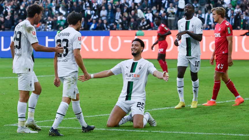Torschütze Ramy Bensebaini (kniend) jubelt mit Joe Scally (l.), Jonas Hofmann (2. v. l.) und Marcus Thuram (2. v. r.) über seinen Treffer zum 4:1 für Borussia Mönchengladbach gegen den 1. FC Köln am 9. Oktober 2022.