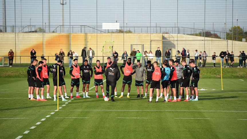 Die Mannschaft von Borussia Mönchengladbach am 12. Oktober 2022 beim Training im Borussia-Park. Trainer Daniel Farke (M.) hat das Team in einem Kreis um sich versammelt.