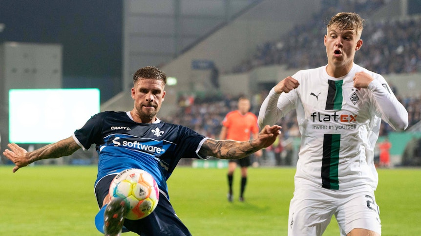 Luca Netz von Borussia Mönchengladbach (r.) im Zweikampf mit Tobias Kempe vom SV Darmstadt 98 beim DFB-Pokal-Spiel am 18. Oktober 2022.