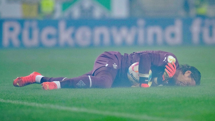 Yann Sommer, Torhüter von Borussia Mönchengladbach, liegt verletzt auf dem Spielfeld während der DFB-Pokal-Partie bei SV Darmstadt 98 (18. Oktober 2022). Sommer hält den Ball dennoch in seinen Armen.