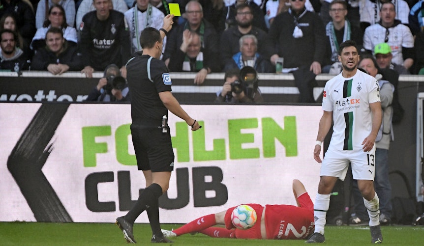 Schiedsrichter Sven Jablonski zeigt Kapitän Lars Stindl von Borussia Mönchengladbach im Bundesliga-Spiel gegen den 1. FC Köln am 9. Oktober 2022 die Gelbe Karte.