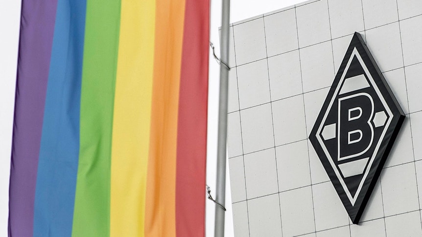 Die Regenbogenfahne im Borussia-Park, im Hintergrund ist das Vereinslogo von Fußball-Bundesligist Borussia Mönchengladbach auf dem Gebäude „8 Grad“ zu sehen.