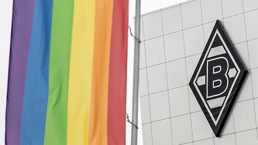 Die Regenbogenfahne im Borussia-Park, im Hintergrund ist das Vereinslogo von Fußball-Bundesligist Borussia Mönchengladbach auf dem Gebäude „8 Grad“ zu sehen.