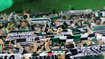 Die Fans von Borussia Mönchengladbach am 11. November 2022 beim Heimspiel gegen Borussia Dortmund in der Nordkurve im Borussia-Park. Tausende Anhänger halten ihre Schals hoch und singen Fan-Lieder.