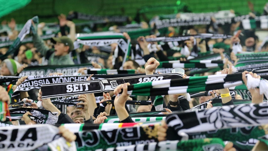 Die Fans von Borussia Mönchengladbach am 11. November 2022 beim Heimspiel gegen Borussia Dortmund in der Nordkurve im Borussia-Park. Tausende Anhänger halten ihre Schals hoch und singen Fan-Lieder.
