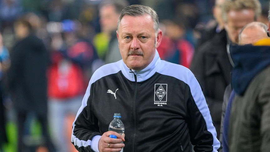 Gladbach-Manager Roland Virkus, auf diesem Foto am 11. November 2022 im Borussia-Park zu sehen. Virkus trägt eine dunkle Trainingsjacke und hält eine Flasche Mineralwasser in seiner rechten Hand.