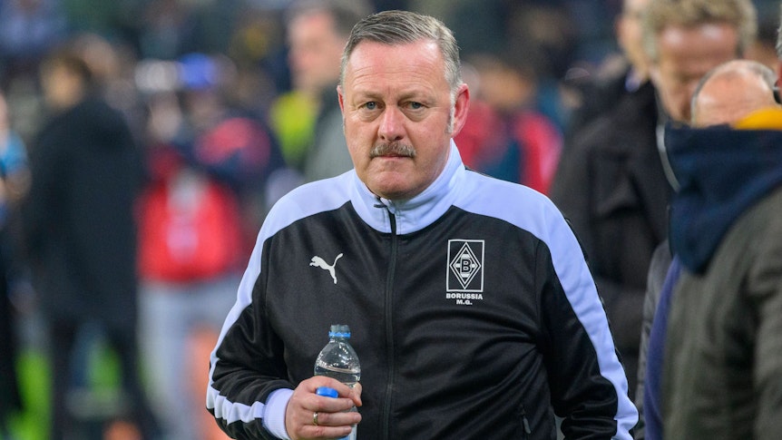 Gladbach-Manager Roland Virkus, auf diesem Foto am 11. November 2022 im Borussia-Park zu sehen. Virkus trägt eine dunkle Trainingsjacke und hält eine Flasche Mineralwasser in seiner rechten Hand.