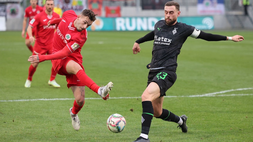 Ein Spieler von Rot-Weiß Oberhausen kommt zum Abschluss, Michel Lieder von Borussia Mönchengladbach blockt den Schuss.