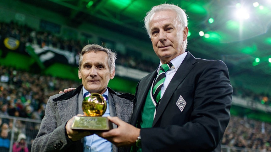 Allan Simonsen und Rainer Bonhof halten die Trophäe von Simonsen als Europas Fußballer des Jahres 1977 im Borusia-Park.