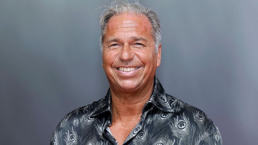 Sportreporter Kai Ebel bei der Verleihung des Staatspreises des Landes Nordrhein-Westfalen an Michael Schumacher am 20. Juli 2022. Er grinst und ist braun gebrannt.