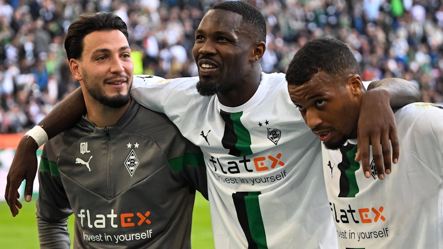Ramy Bensebaini (l.), Marcus Thuram (Mitte) und Alassane Plea (r.) von Borussia Mönchengladbach am 9. Oktober 2022 nach dem Spiel gegen den 1. FC Köln beim Feiern mit den Fans vor der Nordkurve.