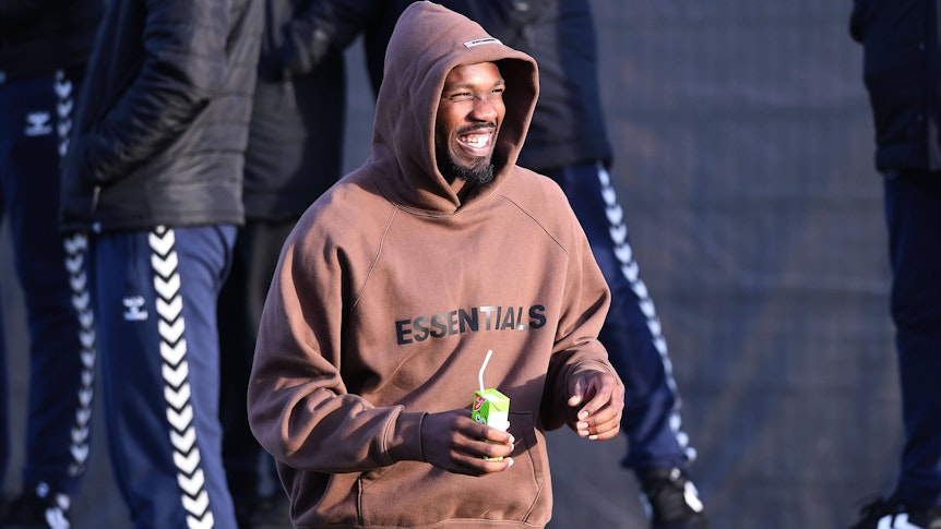 Marcus Thuram, Angreifer von Borussia Mönchengladbach, hier am 7. Januar 2023 beim Testspiel gegen den VfB Oldenburg als Zuschauer im braunen Hoodie mit Kapuze und mit Trinkpäckchen in der Hand.