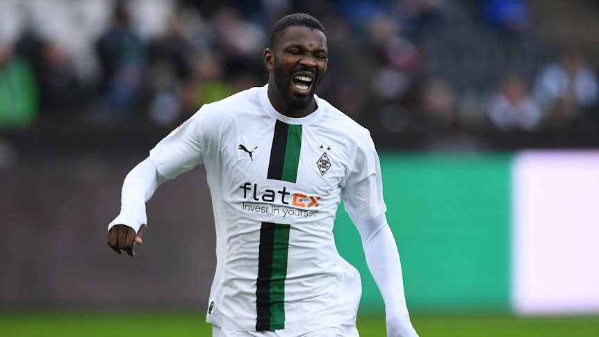 Marcus Thuram schreit vor Schmerz beim Testspiel von Borussia Mönchengladbach gegen den FC St. Pauli am 14. Januar 2023 auf. Der Gladbach-Stürmer hat den Mund weit geöffnet und kneift die Augen zu.