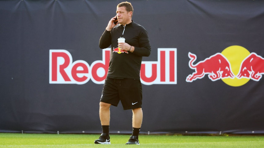 Ex-Gladbach-Manager Max Eberl, hier am 9. Januar 2023 im Trainingscamp seines neuen Klubs RB Leipzig in Abu Dhabi zu sehen. Eberl telefoniert mit seinem Smartphone, in der linken Hand hält er einen Getränkebecher.