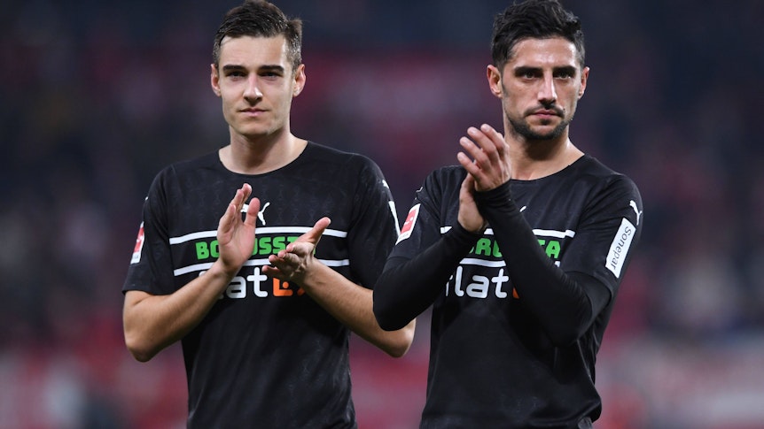 Florian Neuhaus (l.) und Lars Stindl (r.) von Borussia Mönchengladbach, hier am 5. November 2021 beim Auswärtsspiel in Mainz, klatschen nach der Partie den mitgereisten Fans zu. Beuide schauen missmutig und haben ein schwarzes Gladbach-Trikot an.